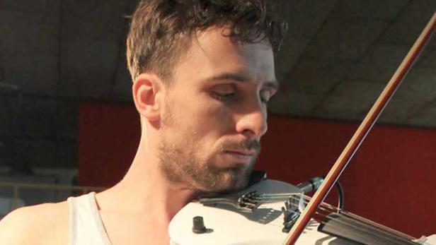 Ein Mann mit Bart spielt auf einer weißen Geige.