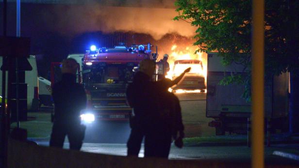 Ein brennendes Auto wird von der Feuerwehr gelöscht.