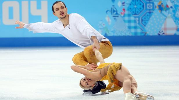 Ein Eiskunstlaufpaar führt eine Hebefigur auf dem Eis vor.