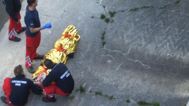 Sanitäter der Berufsrettung Wien versorgen eine verletzte Person, die in eine goldene Rettungsdecke gehüllt ist.