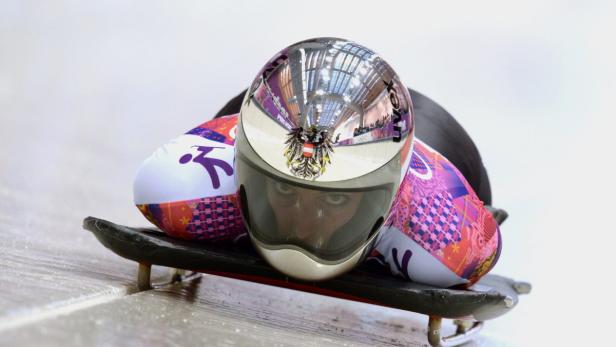 Eine Skeleton-Athletin mit österreichischem Helm liegt auf ihrem Schlitten.