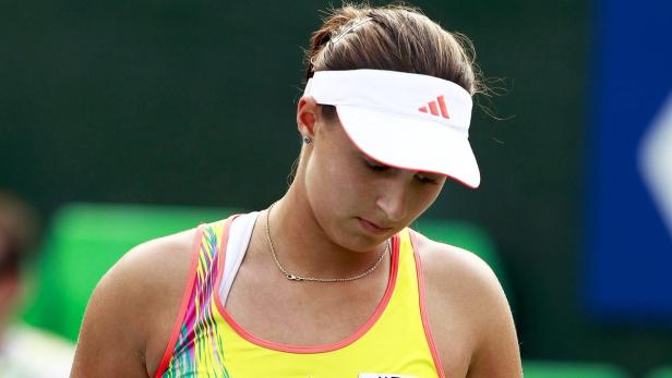 Eine Tennisspielerin mit einem weißen Visier auf dem Platz.