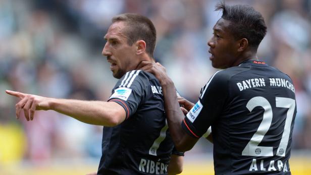 Franck Ribéry zeigt auf etwas, während David Alaba seine Hand auf Ribérys Hals legt.