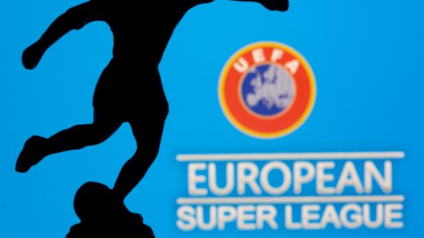 A metal figure of a football player with a ball is seen in front of the words "European Super League" and the UEFA logo in this illustration