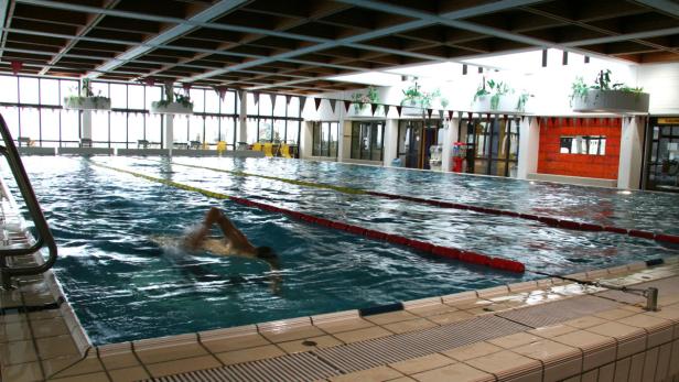 Ein Schwimmer zieht seine Bahnen in einem Hallenbad.