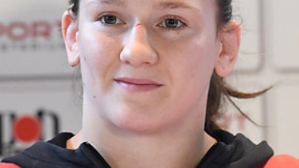 Porträt einer jungen Frau in Sportkleidung mit österreichischen Logos.