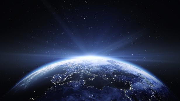 Die Erde bei Nacht, mit hell erleuchteten Städten unter einem Sternenhimmel.