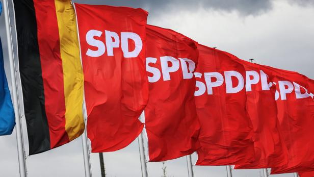 epa03660677 A German and Social Democratic Party (SPD) flags fly in front of dark clouds in Augsburg, Germany, 13 April 2013. On 14 April, a one-day national convention of the SPD is held in Augsburg. EPA/Hannibal Hanschke