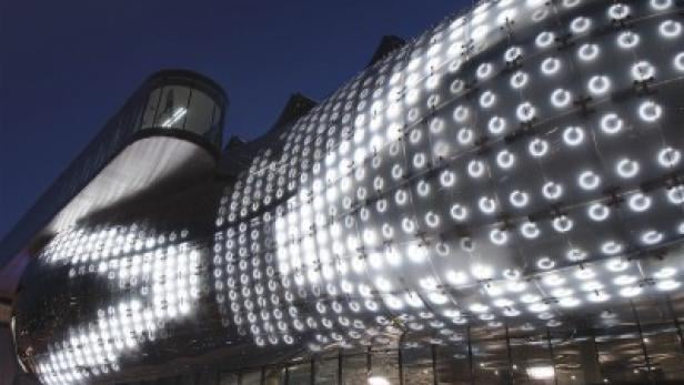 Das Kunsthaus Graz ist nachts beleuchtet.