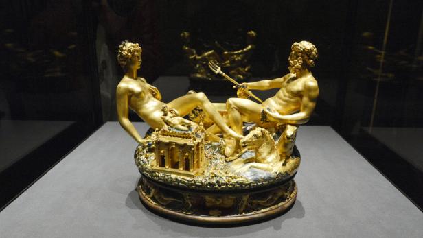 Eine goldene Skulptur von Neptun mit Dreizack und einer weiblichen Figur auf einem verzierten Sockel.