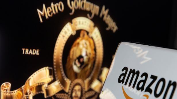 Smartphone with Amazon logo is seen in front of displayed MGM logo in this illustration taken Amazon kauft MGM-Filmstudios für über acht Milliarden Dollar