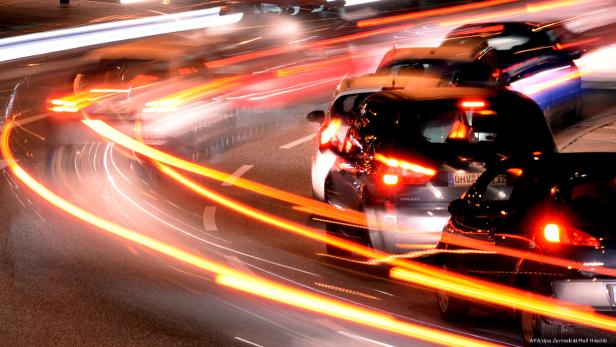 Autos fahren nachts mit hoher Geschwindigkeit auf einer Straße.