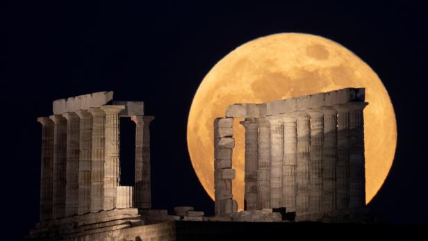 The full moon, known as the "Super Flower Moon" rises over the Temple of Poseidon in Cape Sounion, near Athens