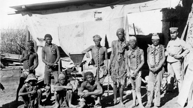 Kriegsgefangene Herero und ein deutscher Soldat im heutigen Namibia