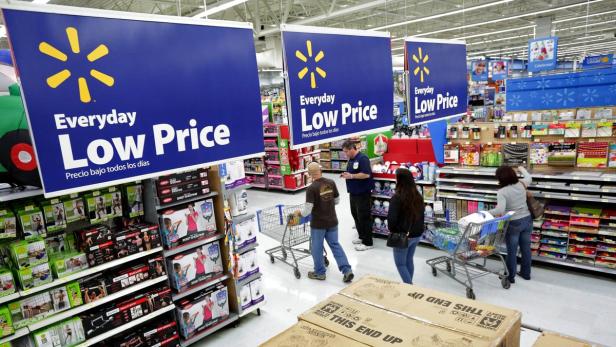 Kunden beim Einkaufen in einem Walmart-Geschäft unter „Everyday Low Price“-Schildern.