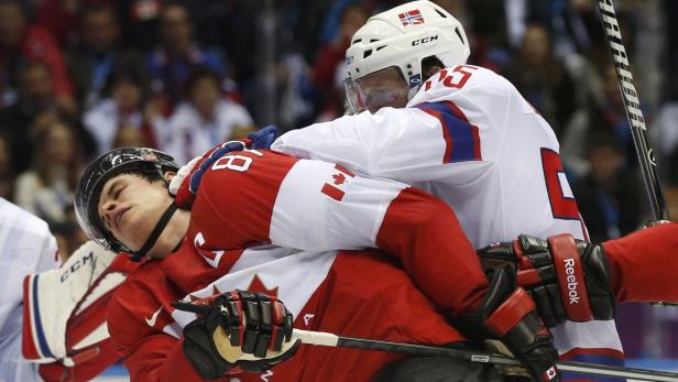 Ein kanadischer Eishockeyspieler wird von einem norwegischen Spieler zu Fall gebracht.