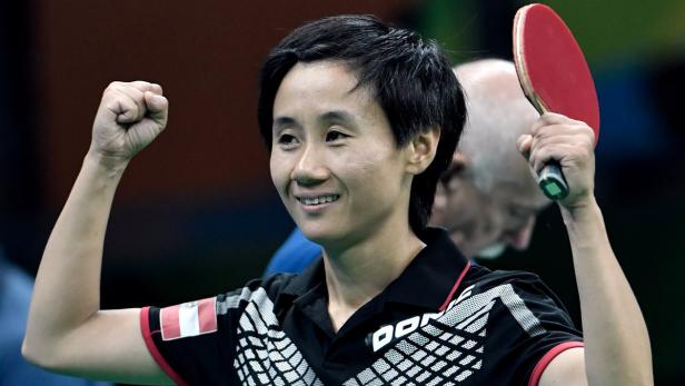 Eine Tischtennisspielerin jubelt mit erhobener Faust und Schläger.