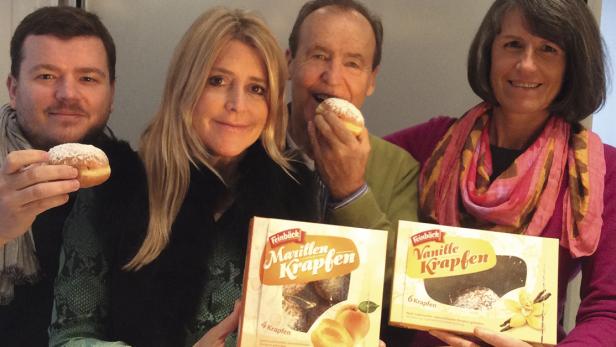 Vier Personen präsentieren und essen „Feinbäck“-Krapfen mit Marillen- und Vanillefüllung.