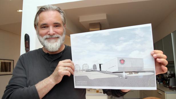 Ein Mann mit Bart präsentiert den Entwurf eines Gebäudes von Architekt Claus Ullrich.