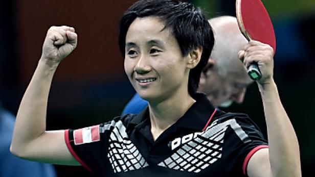 Eine Tischtennisspielerin jubelt mit erhobener Faust und Schläger.