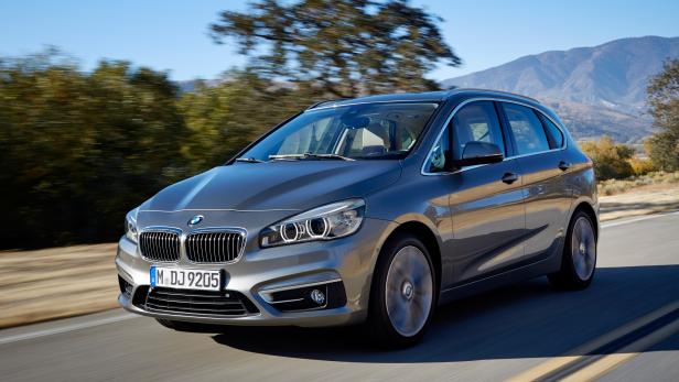 Ein grauer BMW 2er Active Tourer fährt auf einer Landstraße.