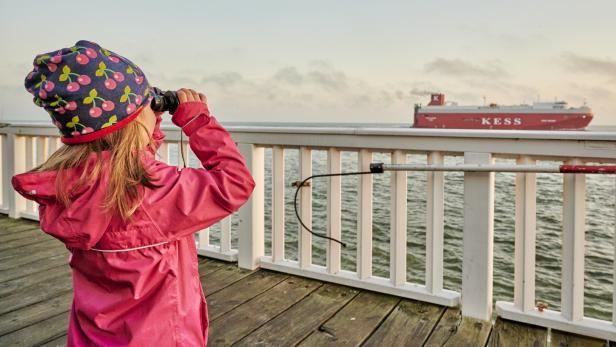 Mädchen beobachtet Schiffe in Cuxhaven/ Alte Liebe