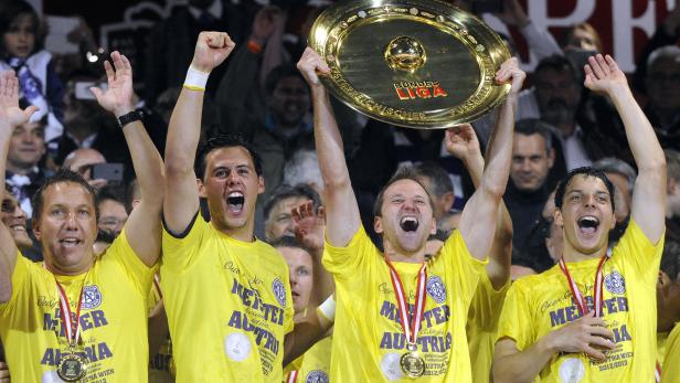 Jubelnde Fußballspieler des FK Austria Wien mit der Meisterschale der österreichischen Bundesliga.
