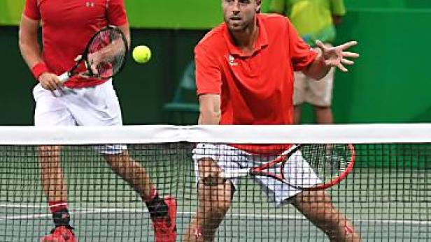 Zwei Tennisspieler während eines Doppelspiels auf einem Tennisplatz.