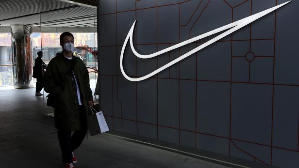 FILE PHOTO: Man walks past a Nike Inc store at a shopping complex in Beijing