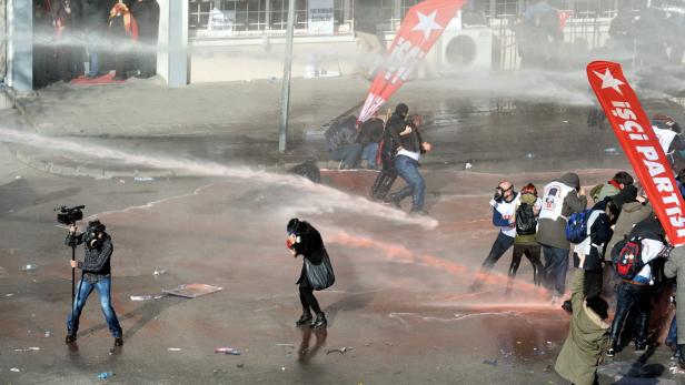 Bei einer Demonstration werden Menschen mit einem Wasserwerfer beschossen.