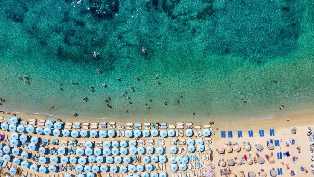 Aerial top down view to the famous beach of Psarou on Mykonos island