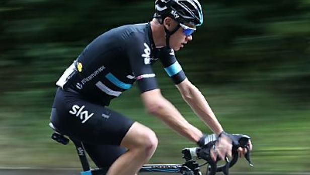 Ein Radfahrer in schwarzer Sky-Team-Bekleidung fährt auf einer Straße.