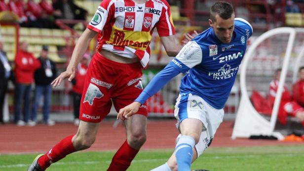 Zwei Fußballspieler im Zweikampf auf dem Spielfeld.