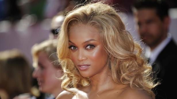 Ein Porträt von Tyra Banks mit blond gelocktem Haar.