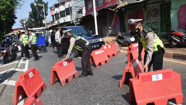 Police officers hold barriers during the imposition of large-scale social restrictions by the government to prevent the spread of the coronavirus disease (COVID-19)