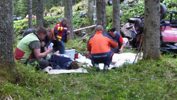 Die Bergrettung versorgt eine verletzte Person nach einem Unfall im Wald.