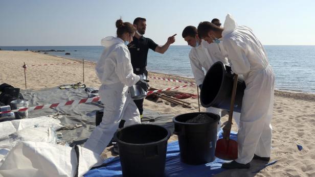 Spezielle Feuerwehrkräfte säubern einen Strand in Korsika. Die Verschmutzung kam mutmaßlich von einem Schiff