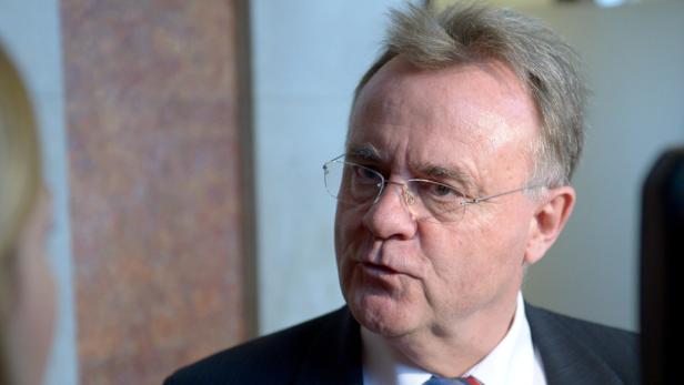 Ein Mann mit Brille und Anzug schaut aufmerksam zur Seite.