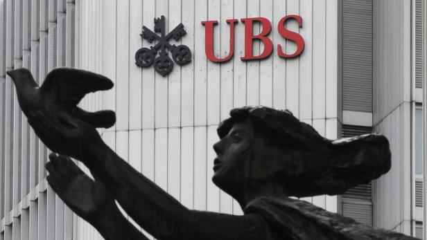 Eine Statue einer Frau, die eine Taube vor einem UBS-Gebäude freilässt.