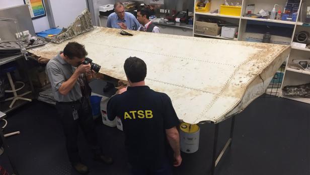 Experten untersuchen ein gefundenes Flugzeugteil