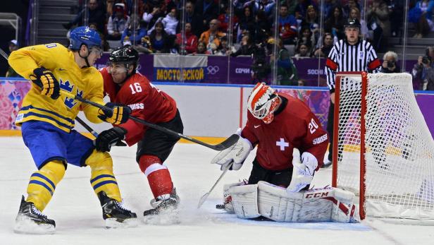 Ein Eishockeyspiel zwischen Schweden und der Schweiz, bei dem der Schweizer Torwart einen Schuss abwehrt.