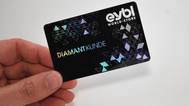 Eine Hand hält eine schwarze Kundenkarte von eybl World-Store mit der Aufschrift „Diamant Kunde“.
