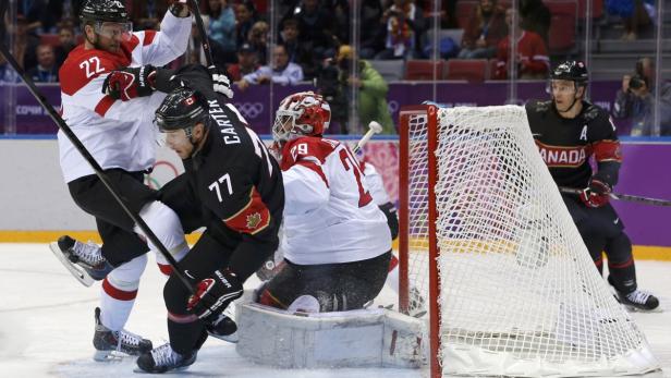 Eishockeyspieler kämpfen vor dem Tor um den Puck.