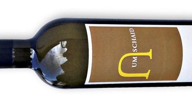 Eine liegende Flasche Weißburgunder der Marke UMSCHAID.
