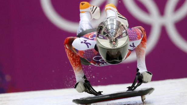 Ein Skeleton-Athlet liegt auf seinem Schlitten und rast die Eisbahn hinunter.