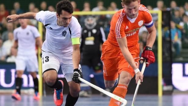 Zwei Hockeyspieler kämpfen um den Ball während eines Spiels.