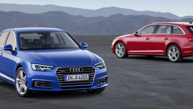 Ein blauer Audi A4 und ein roter Audi A4 Avant stehen vor einer Bergkulisse.