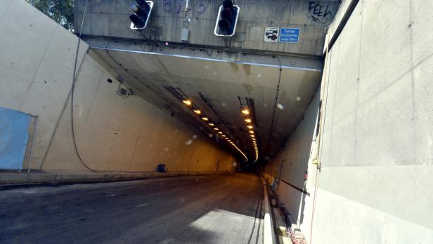 Blick in einen Tunnel mit Ampeln und Beleuchtung.