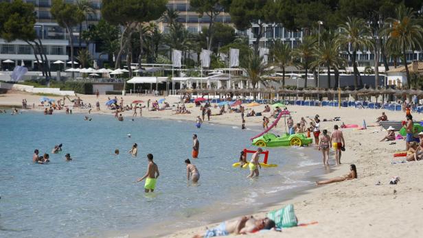 FILE PHOTO: People sunbathe at Magaluf beach in Mallorca