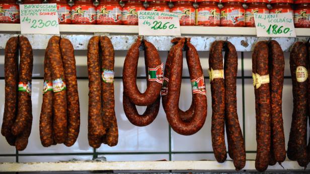 Verschiedene ungarische Wurstsorten hängen zum Verkauf aus.